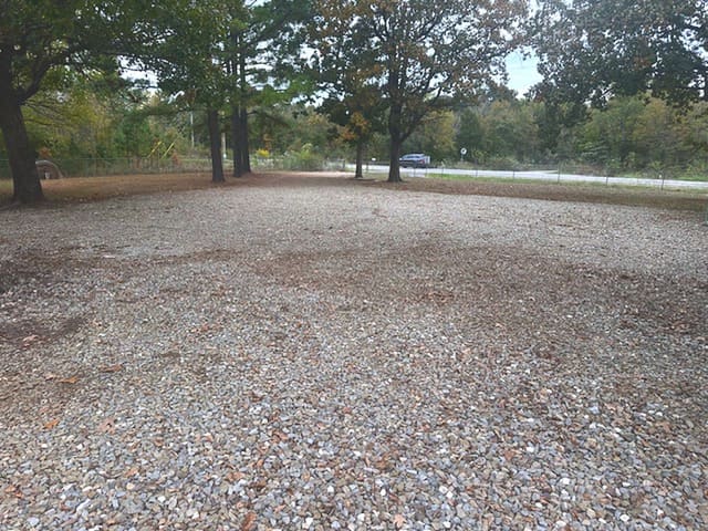 Open gravel turnaround with room for trailers, and a paved road right to the gate