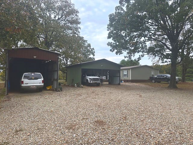 Gravel parking by the shop, with room for trucks and trailers