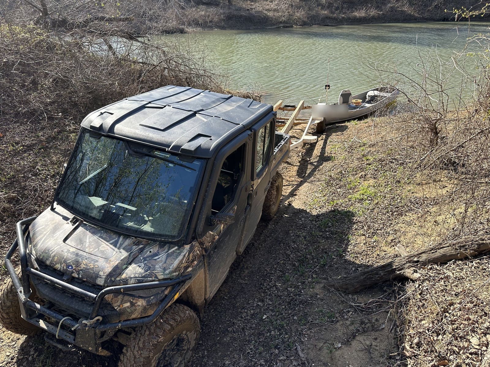 A UTV and a jon boat at the stocked fishing pond